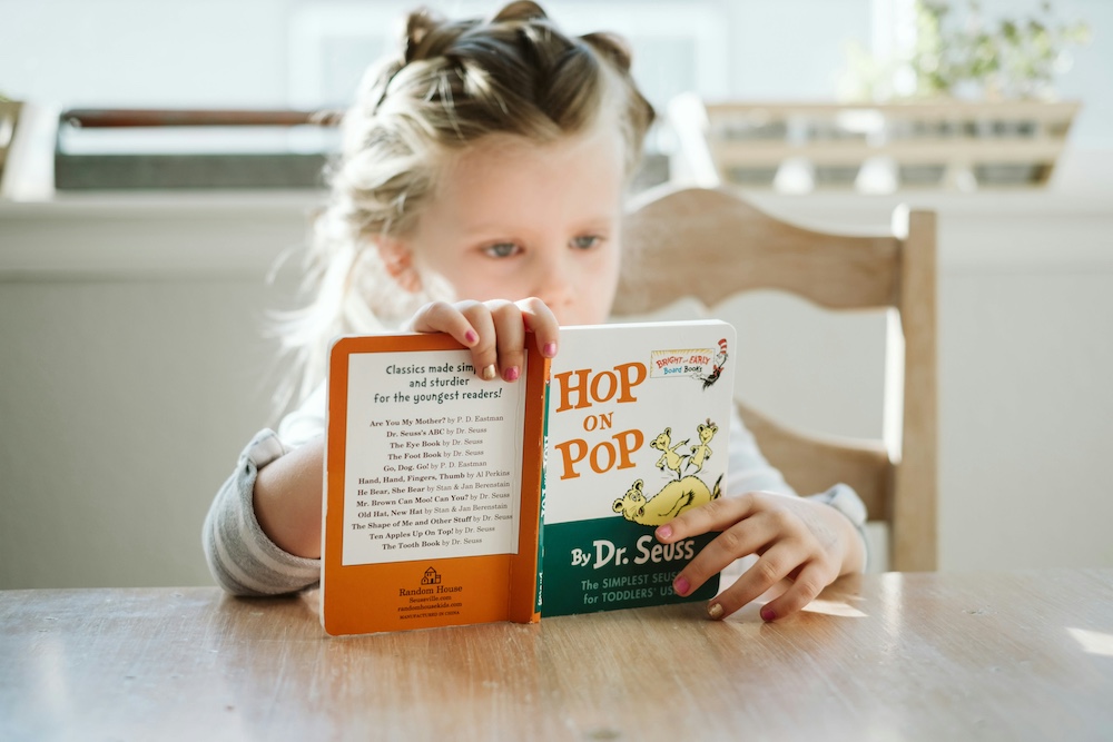 A child reading a book at a table